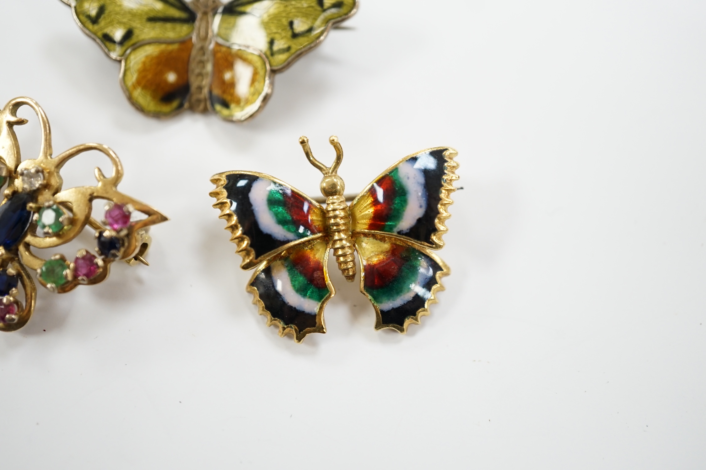 Three assorted butterfly brooches, sterling and enamel, 18k and enamel and 9ct gold and gem set, width 25mm.